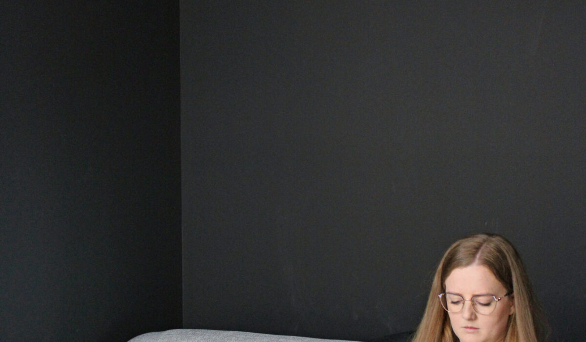 girl sat on sofa with laptop